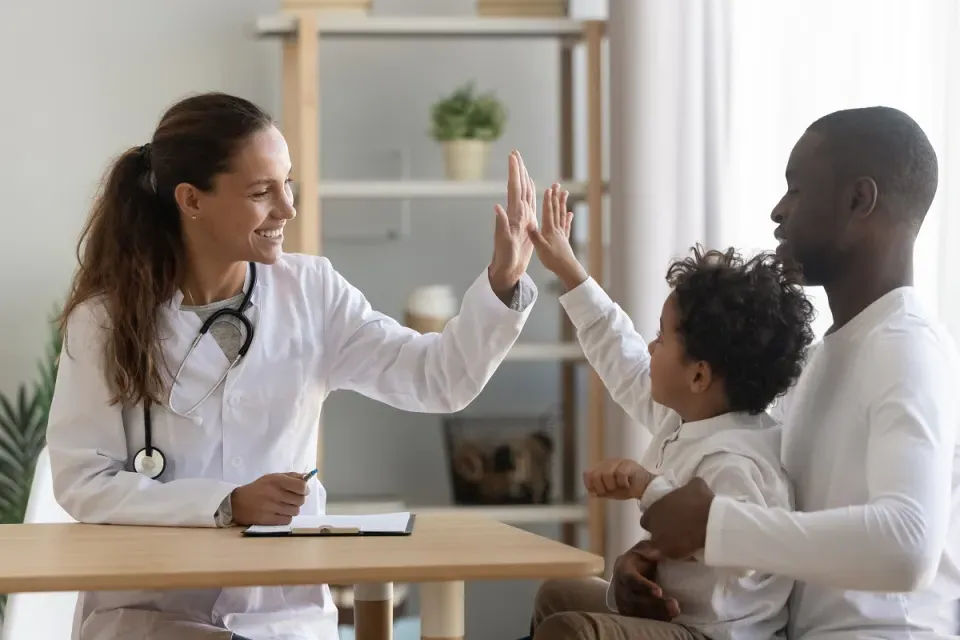 Family Nurse Practitioner High Fiving Pediatric Patient